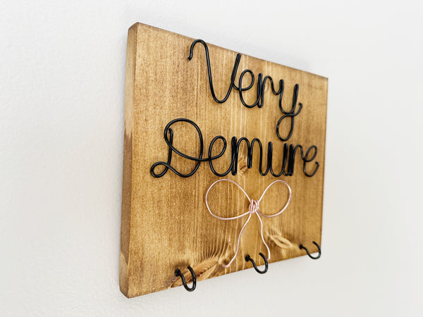 Demure Bow Sign