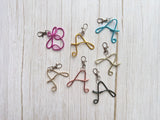 Personalized wire initial keychains and bag charms featuring handmade monogram letters in assorted colors.
