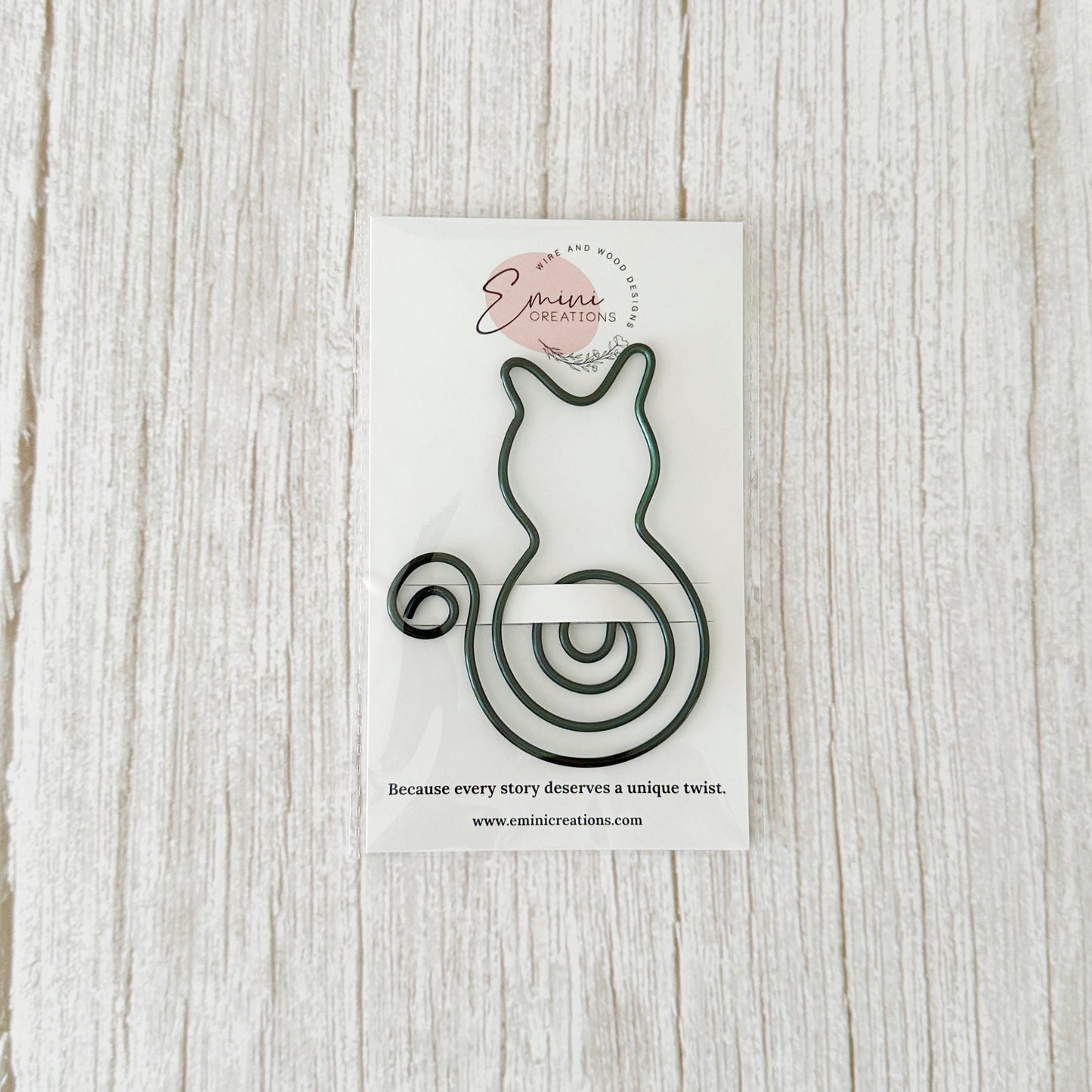 Bookmark cat design on a white card with Emini Creations branding, on a light wooden surface.