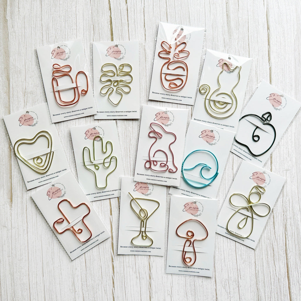 Set of decorative wire art booksmarks or planner clips on a wooden surface