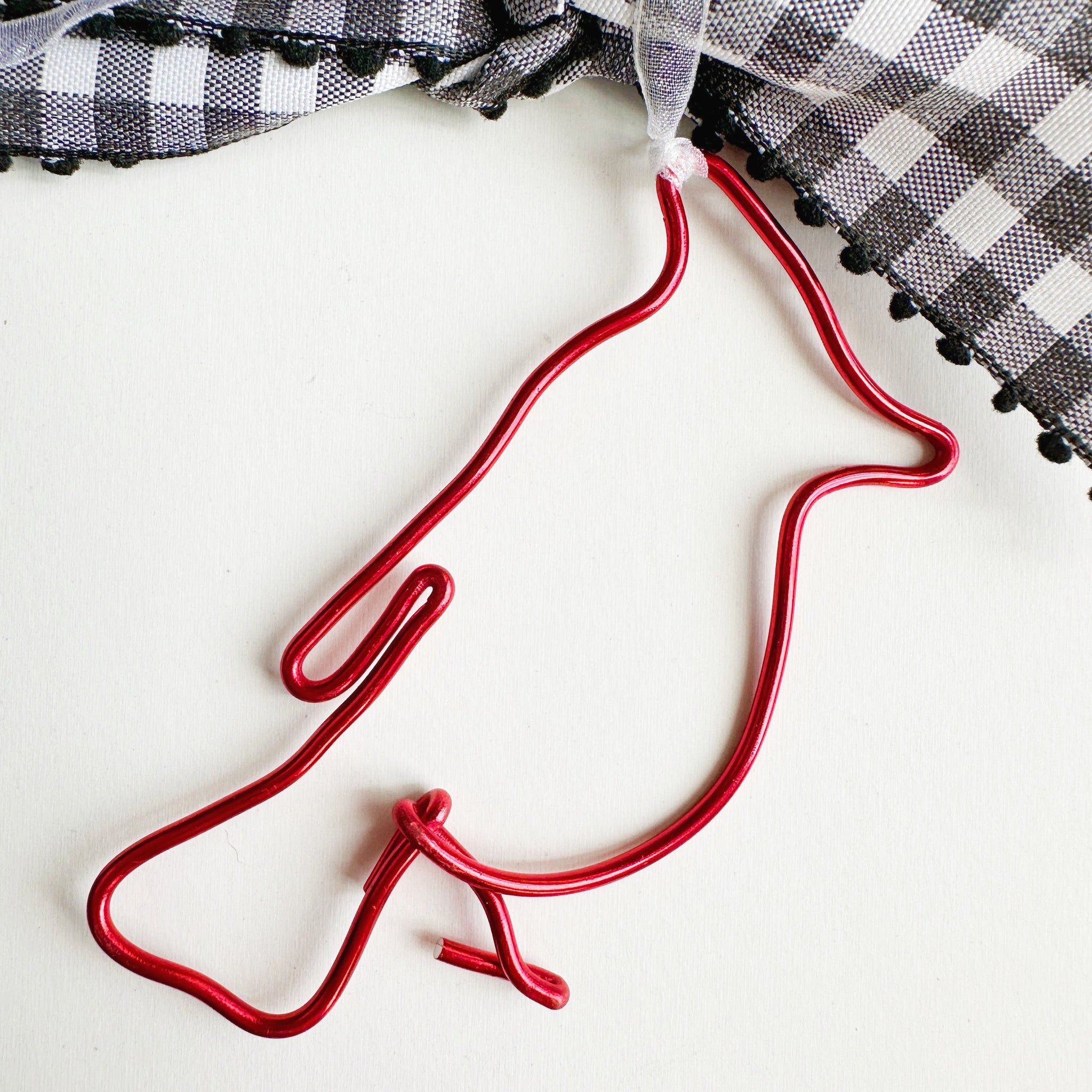 Red wire cardinal on a white gift box with a checkered bow. 