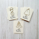 Three Christmas-themed cards with handcrafted wire art designs of a snowman, bell and Christmas tree on a wooden surface.