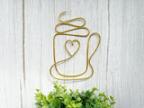 Decorative wall art of a mug with a heart on a light wooden background
