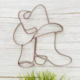 Handcrafted wire art of cowgirl boots and hat in mocha wire, hanging on a white wall with neutral western decor.