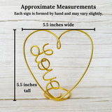 Heart-shaped wire sign with 'love' word, shown with measurements of  5.5"H x 5.5"W on a wooden background.