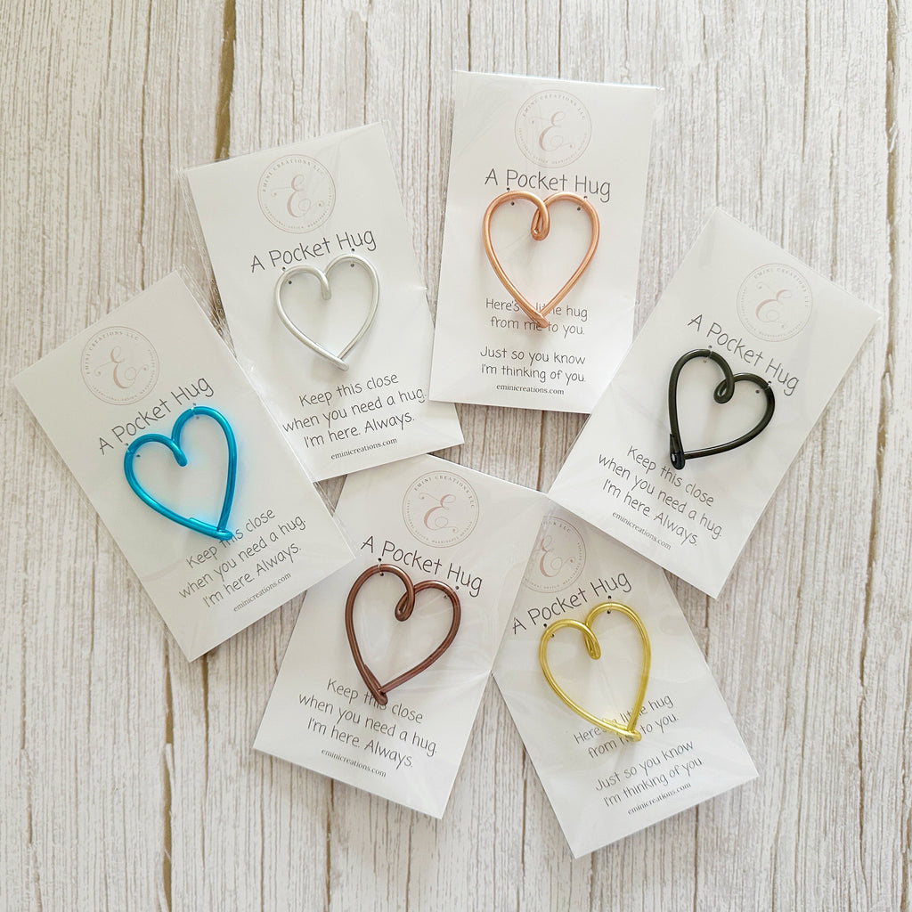 Heart-shaped clips on cards with text on a wooden surface
