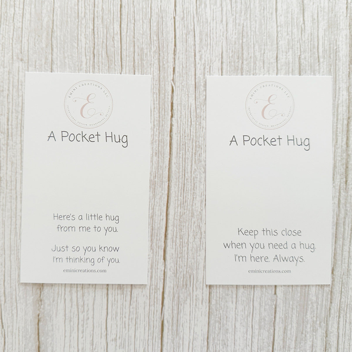 Two 'A Pocket Hug' cards on a wooden surface