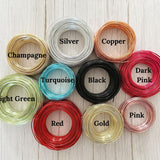Color options for custom wire art including Black, Copper, Turquoise, Gold, Champagne, Red, Pink, Dark Pink and Silver—coiled wire samples displayed on a light textured background.