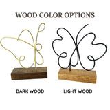 Two decorative butterfly stands on wooden bases, one dark wood and one light wood, with text indicating wood color options.